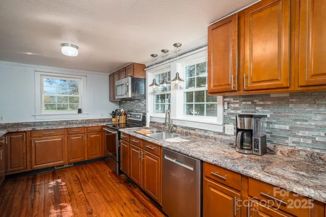 a kitchen with granite countertop stainless steel appliances a stove sink and microwave