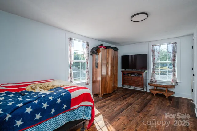 a bedroom with a bed a dresser and a television