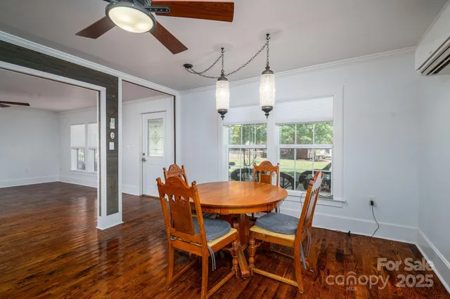 a dining room with furniture a chandelier and wooden floor