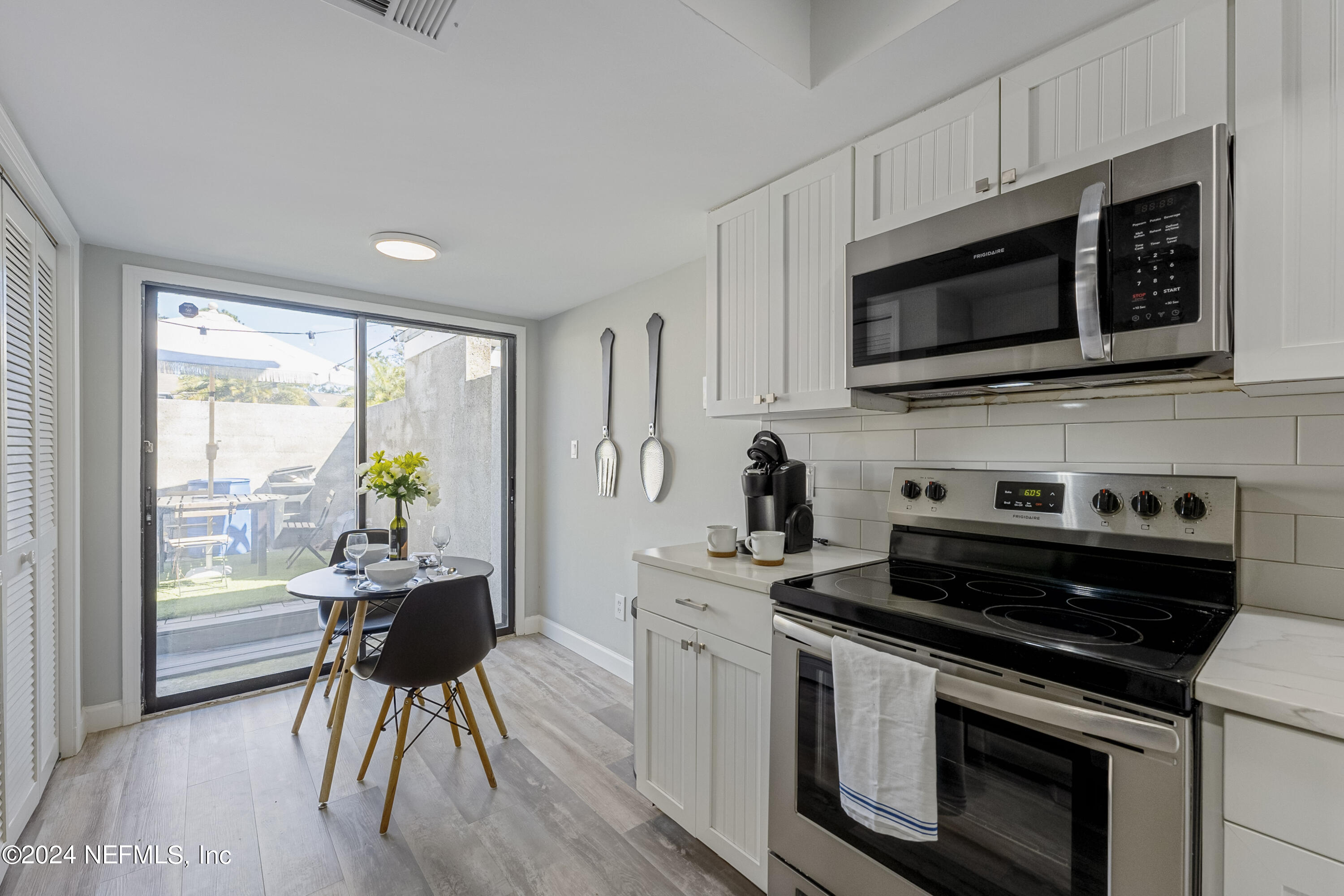 8118 Baymeadows Circle East, Unit 5 Jacksonville, FL 32256 - Photo 10 of 23 a kitchen with a stove a microwave and white cabinets