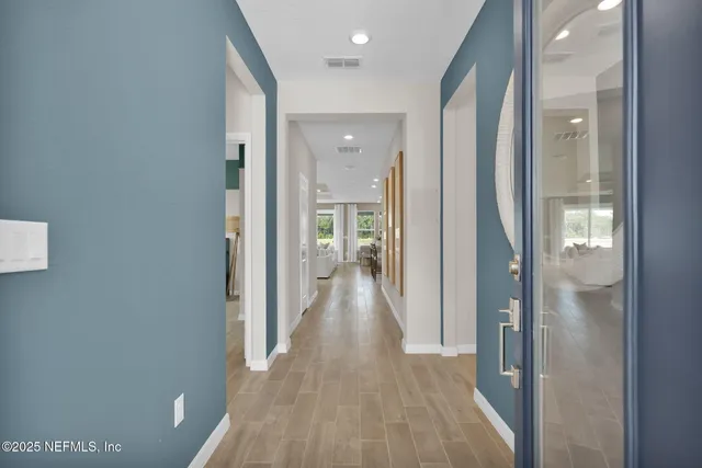 a view of a hallway with wooden floor