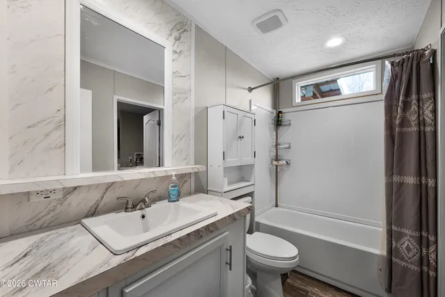 a bathroom with a sink toilet tub and shower