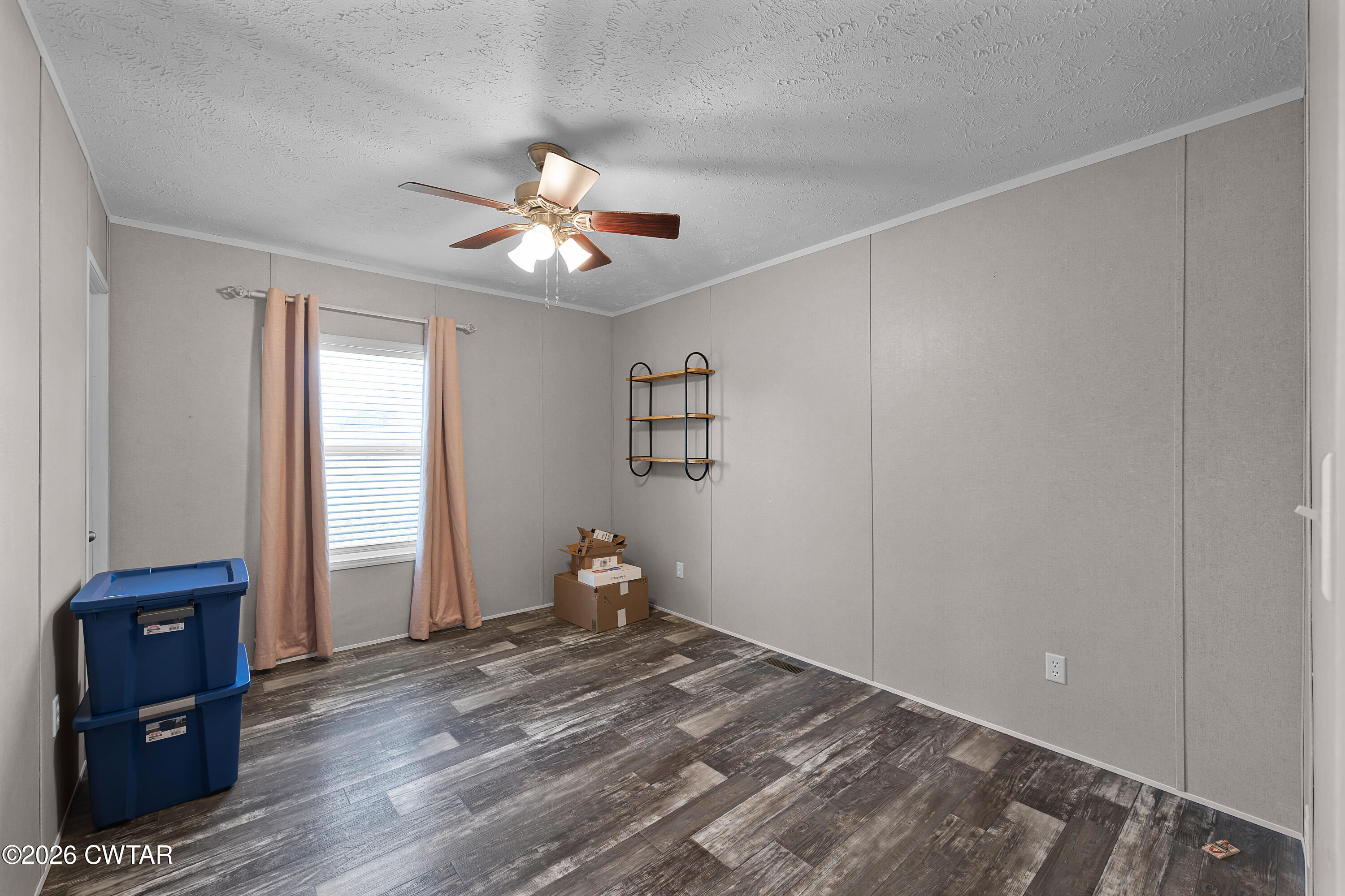 77 Vernon White Road Bradford, TN 38316 - Photo 14 of 24 a view of a livingroom with wooden floor and a ceiling fan
