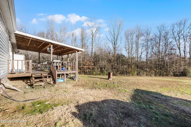 a view of a backyard with table and chairs under an umbrella