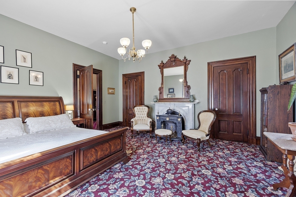 2 West Main Street Brookfield, MA 01506 - Photo 33 of 42 a spacious bedroom with a bed a chandelier and dresser