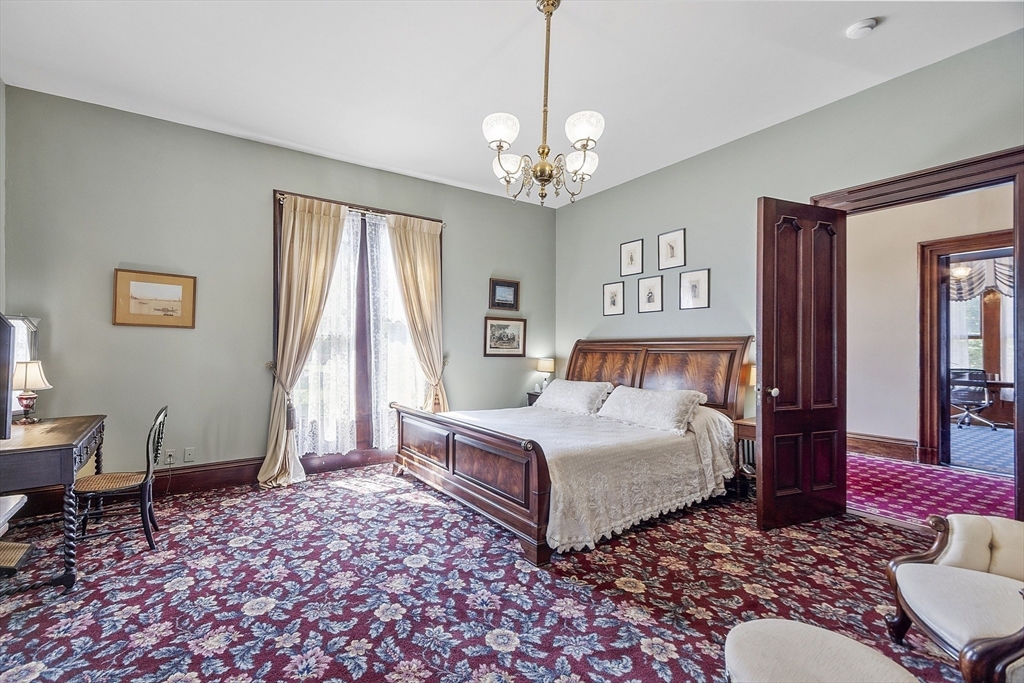 2 West Main Street Brookfield, MA 01506 - Photo 34 of 42 a bedroom with a large bed and a chandelier