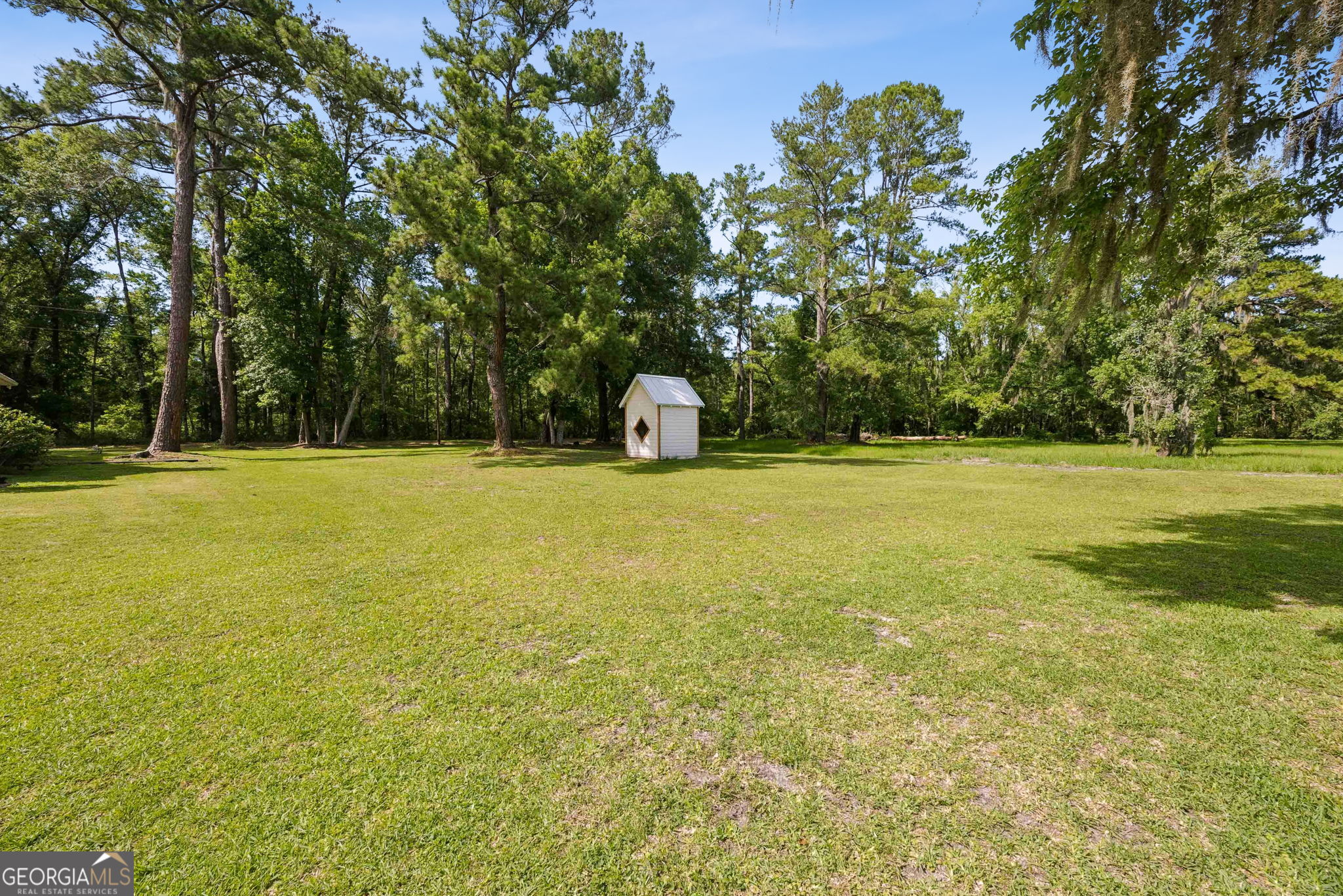 706 Hopewell Point Road White Oak, GA 31568 - Photo 74 of 84 The expansive lawn offers endless possibilities for recreation, gardening, or outdoor entertaining, complemented by a detached storage building.