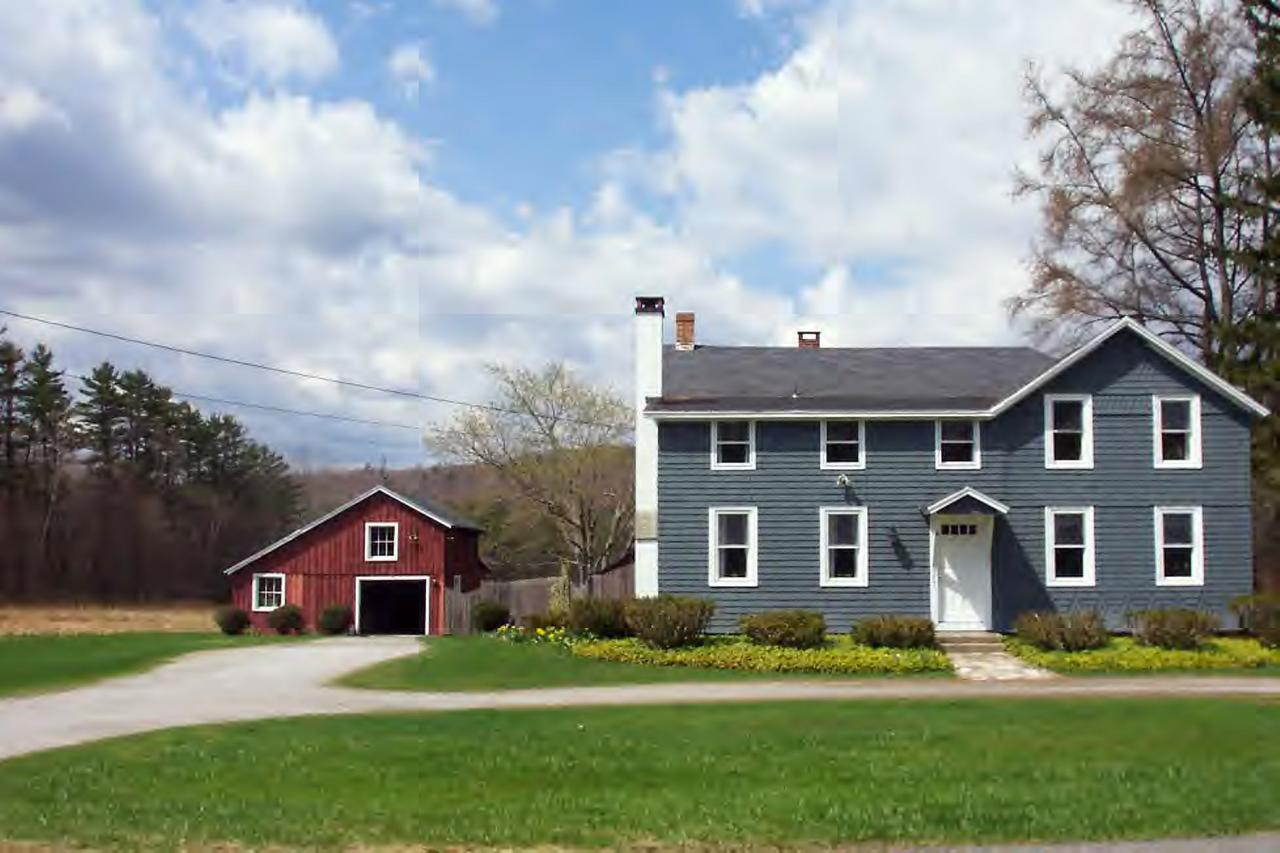 685 W Road Lee, MA 01238 - Photo 1 of 7 a front view of a house with a garden and plants