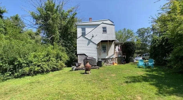 a view of backyard with a chair under a large tree