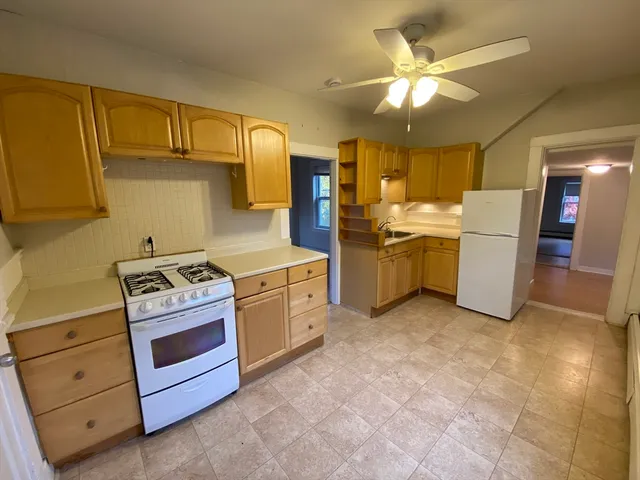 a kitchen with a stove top oven cabinets and a refrigerator