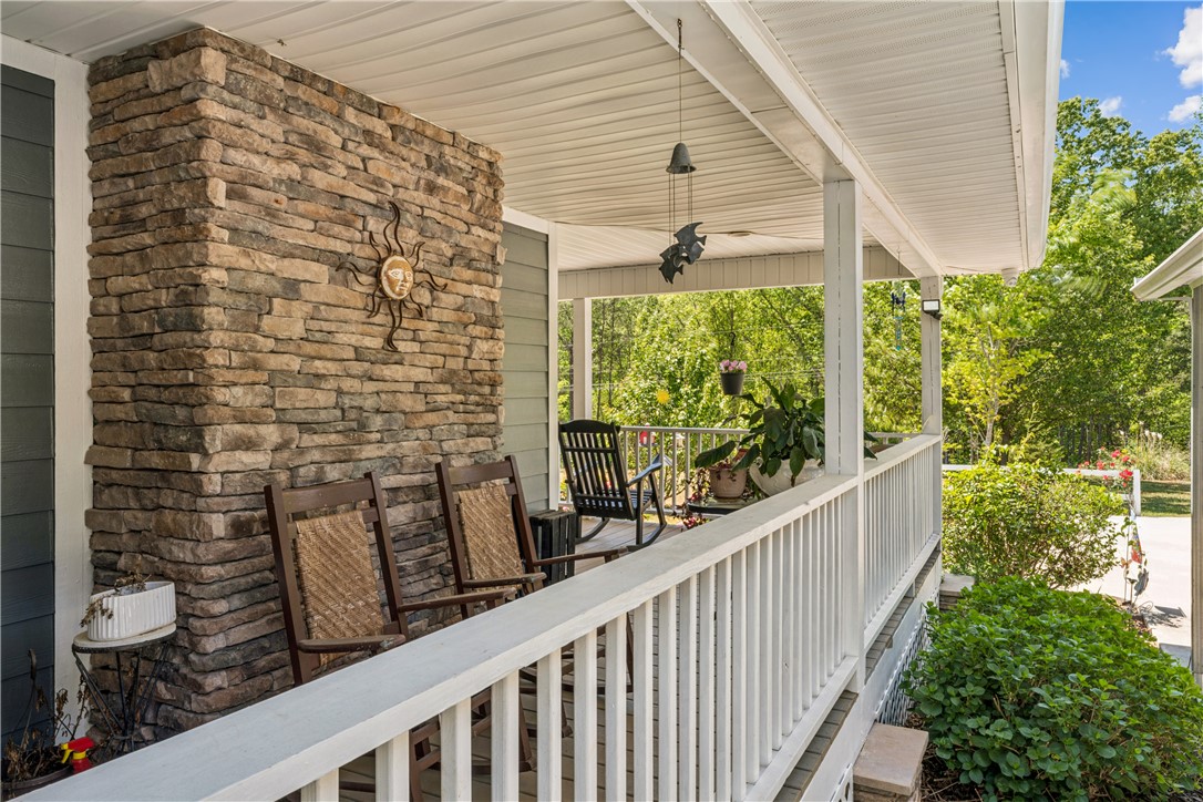 189 Little Choestoea Road Westminster, SC 29693 - Photo 36 of 38 Relax on this charming covered porch, perfect for enjoying peaceful outdoor moments amidst lush greenery.