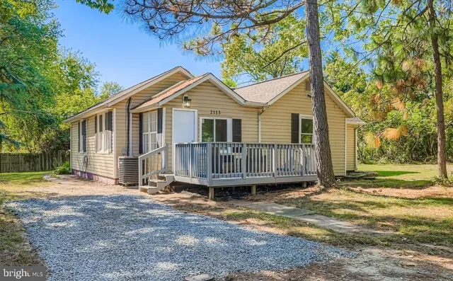 a view of a house with a yard and wooden fence