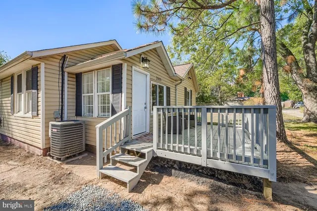 a view of a house with a small yard and wooden fence