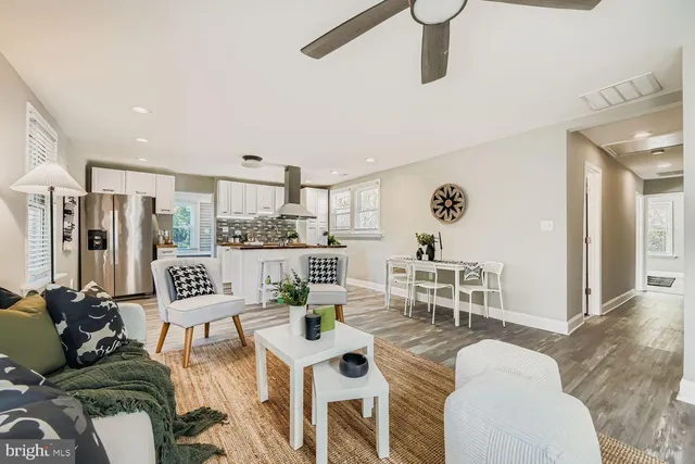 a living room with furniture kitchen view and a large window