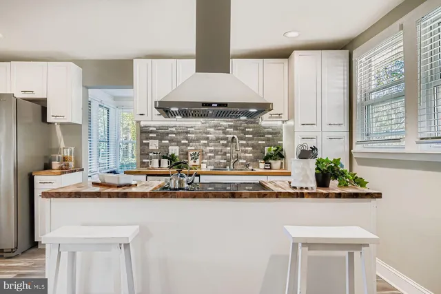 a kitchen with kitchen island granite countertop a sink and a stove