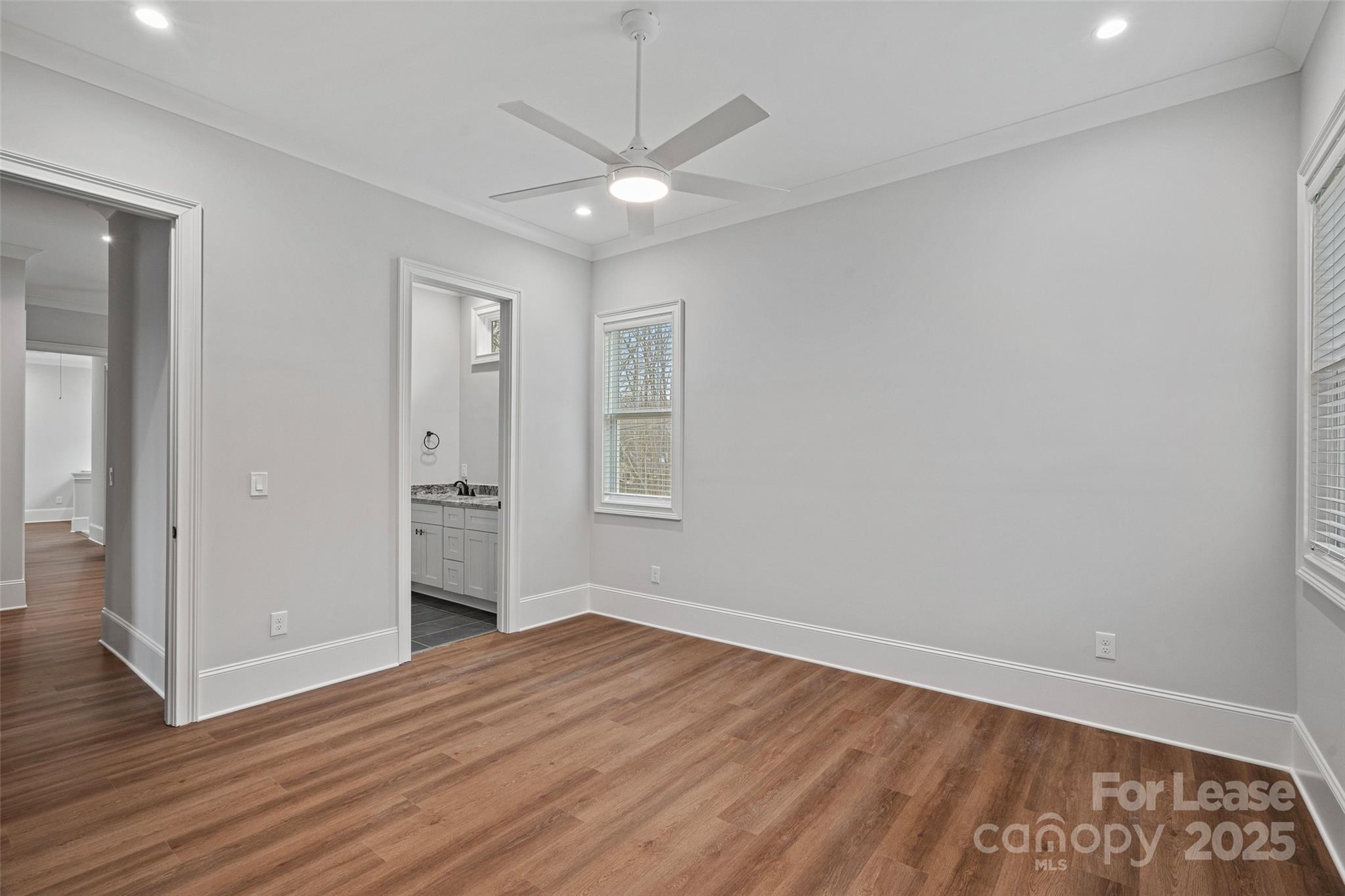 805 Naples Drive Davidson, NC 28036 - Photo 6 of 16 an empty room with wooden floor and a ceiling fan