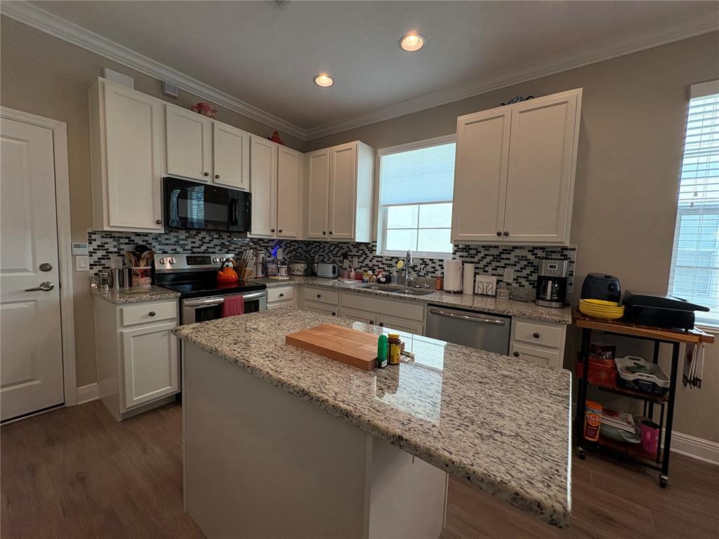 103 Cutlass Way Oldsmar, FL 34677 - Photo 11 of 20 a kitchen with granite countertop a sink a counter top space appliances and cabinets