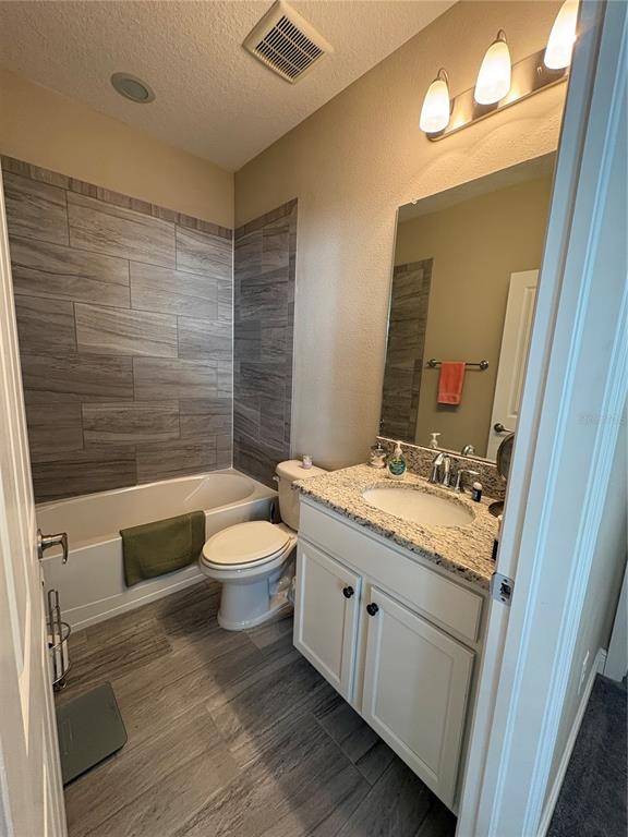 103 Cutlass Way Oldsmar, FL 34677 - Photo 17 of 20 a bathroom with a granite countertop toilet a sink and a mirror
