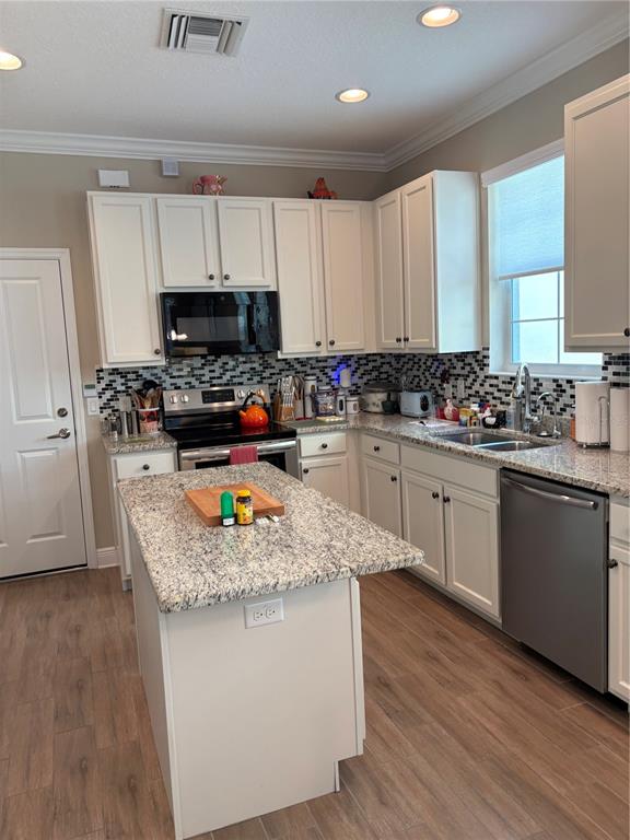 103 Cutlass Way Oldsmar, FL 34677 - Photo 10 of 20 a kitchen with kitchen island granite countertop a sink cabinets and wooden floor