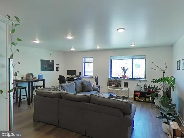 a living room with furniture a window and a flat screen tv