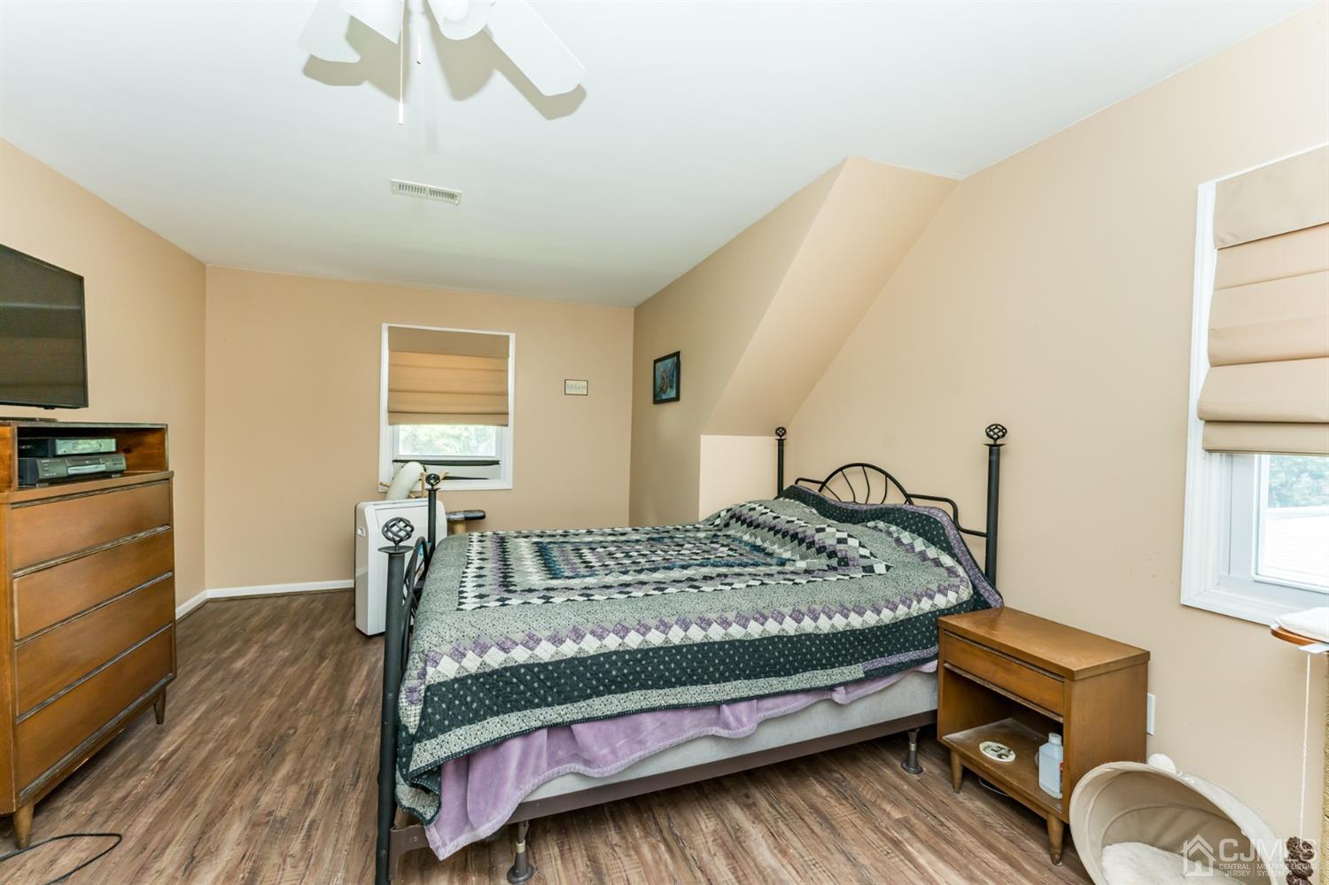 28 West Upper Ferry Road Ewing, NJ 08628 - Photo 12 of 19 a bedroom with a bed and a flat tv screen on the dresser