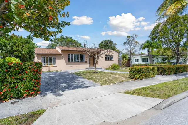 a view of a backyard with large trees and a small barn
