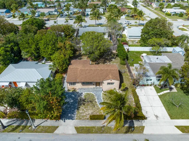 an aerial view of residential houses with outdoor space and trees all around