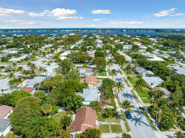 an aerial view of residential houses with outdoor space and trees