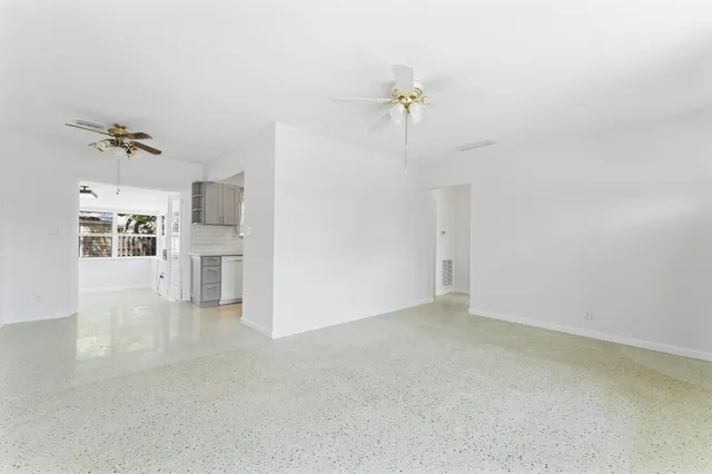 a large white kitchen with kitchen island a sink stainless steel appliances and cabinets