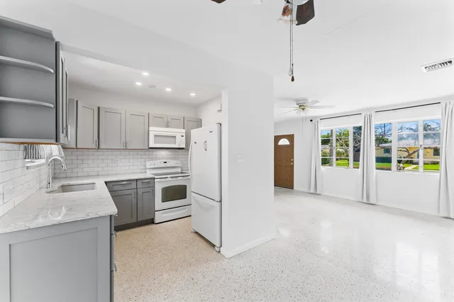 a kitchen with a sink cabinets stainless steel appliances and a window