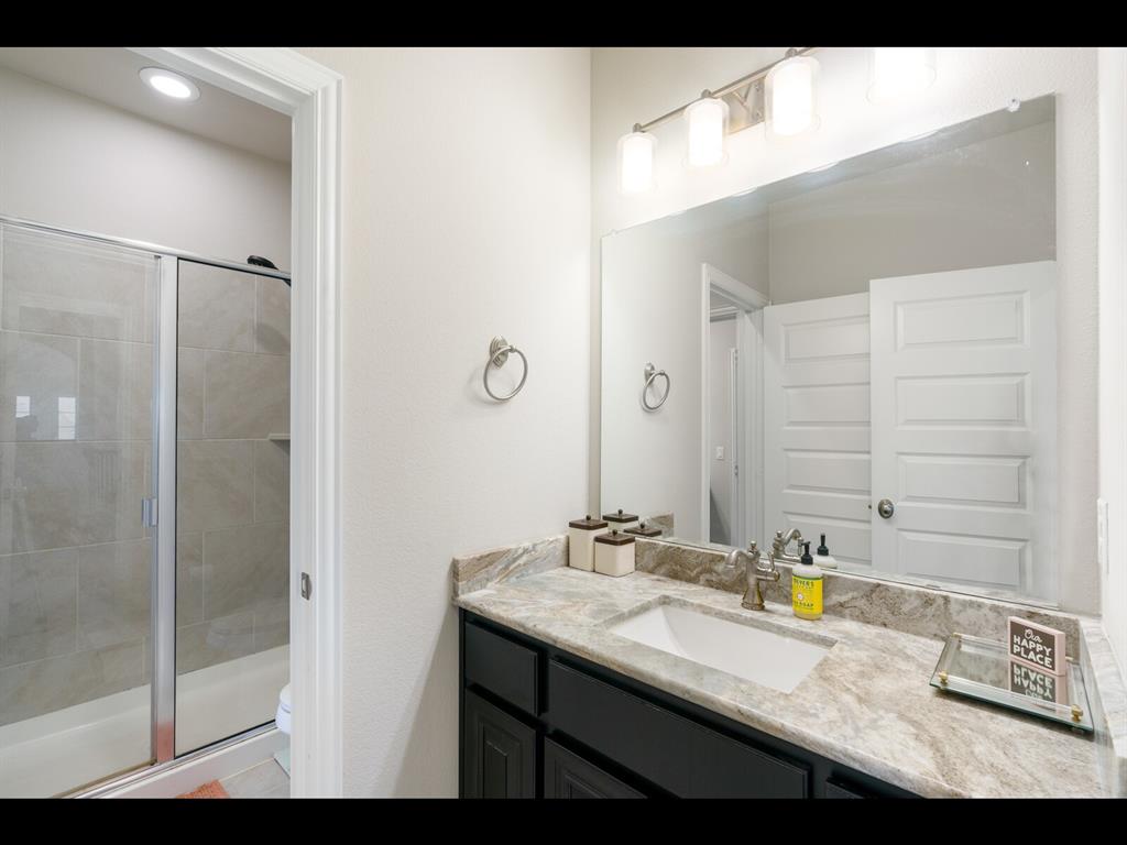 191 Daniel Drive Van Alstyne, TX 75495 - Photo 19 of 32 a bathroom with a granite countertop sink a mirror and a shower