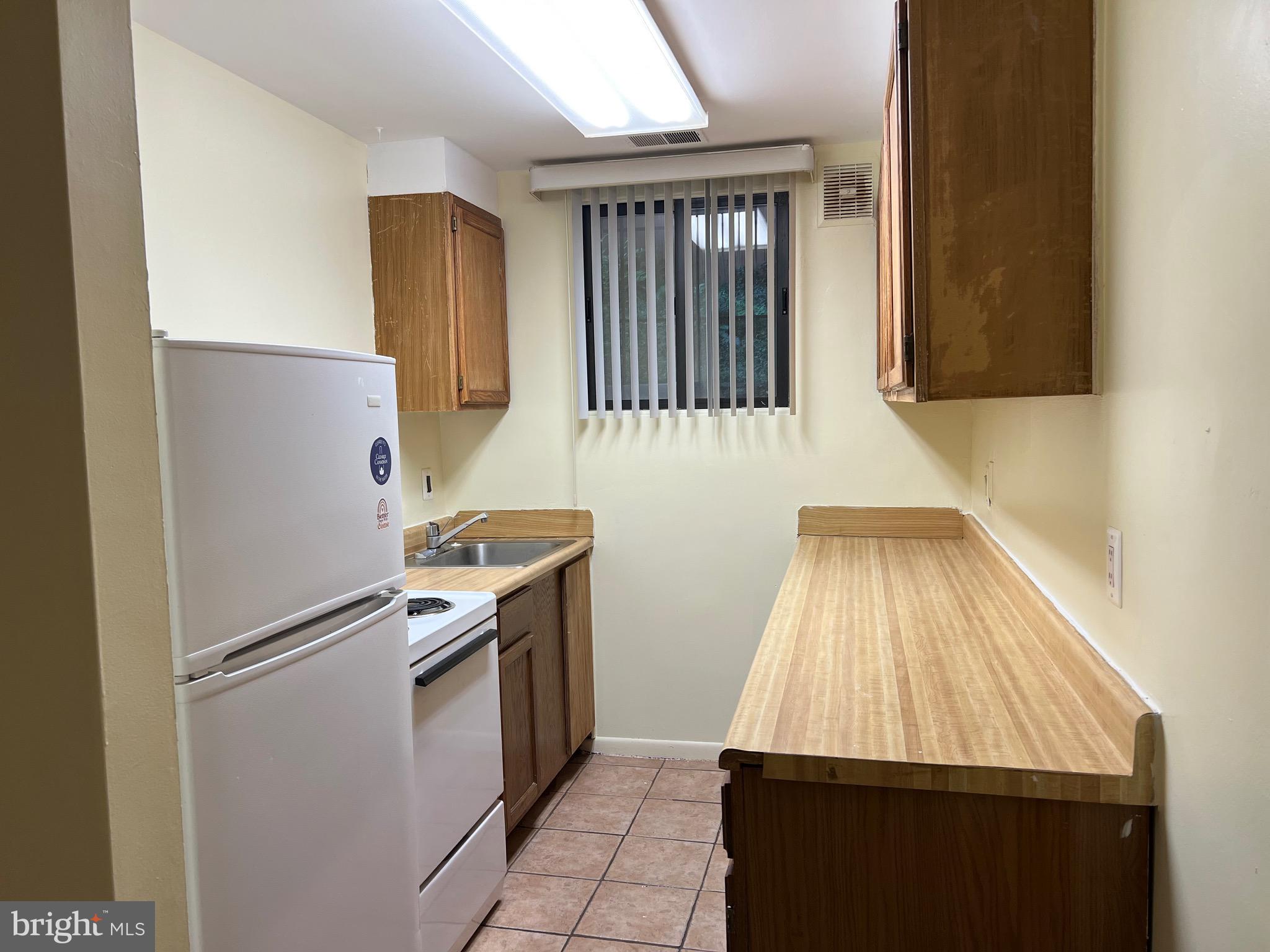 707 Schindler Drive Silver Spring, MD 20903 - Photo 5 of 8 a kitchen with white cabinets and black stainless steel appliances