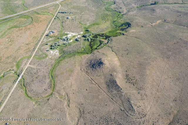 a view of a dry yard with mountains in the background