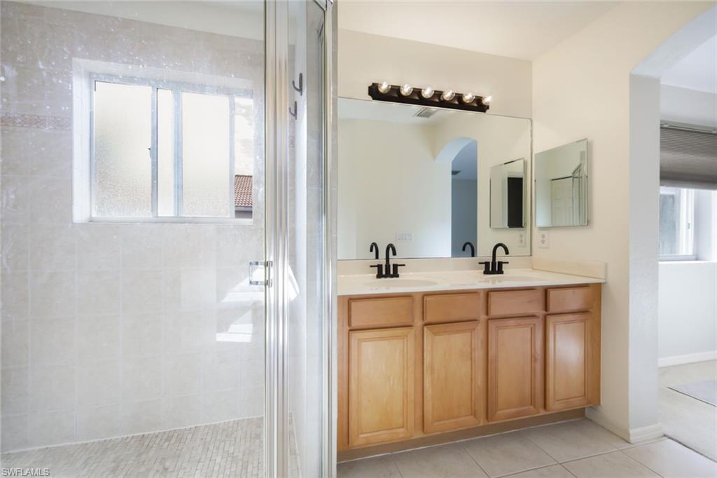 10004 Ravello Boulevard Fort Myers, FL 33905 - Photo 18 of 42 a bathroom with a double vanity sink a mirror and shower