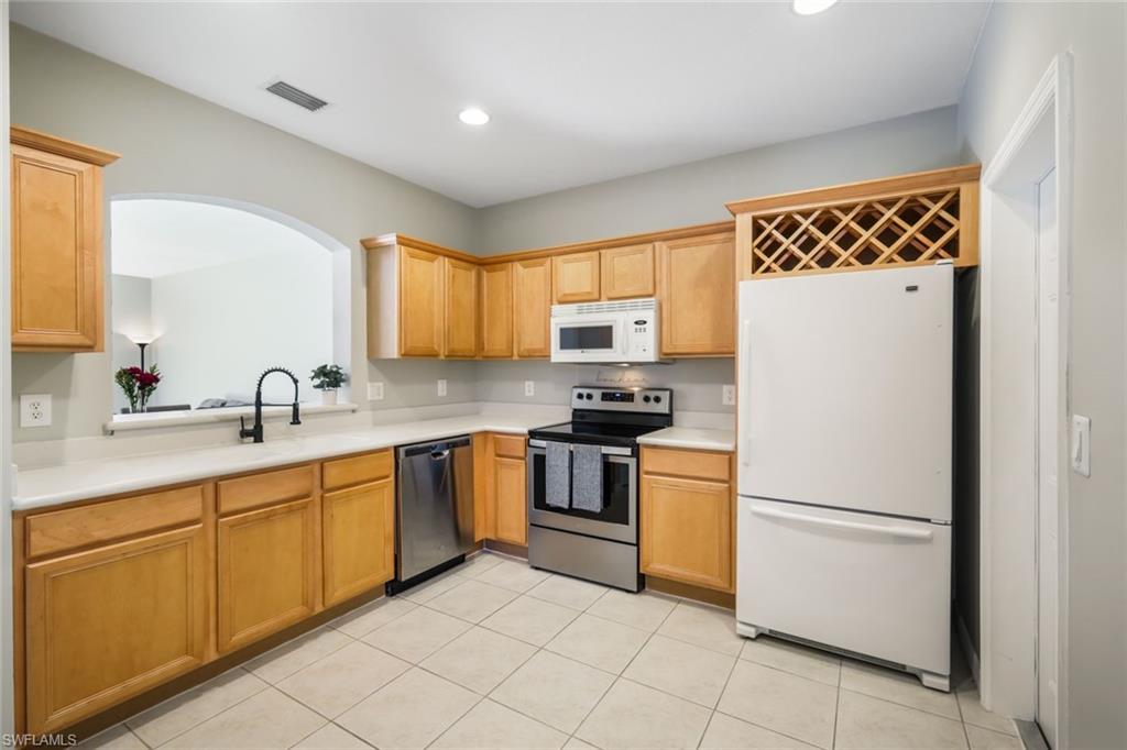 10004 Ravello Boulevard Fort Myers, FL 33905 - Photo 7 of 42 a kitchen with a refrigerator sink and cabinets
