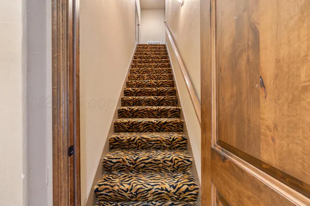 a view of a hallway with wooden floor and stairs