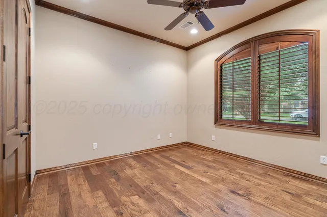an empty room with a ceiling fan and windows