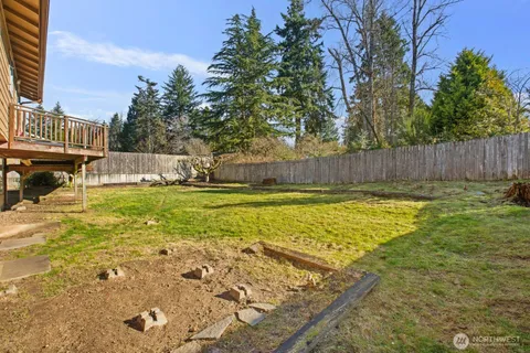 a view of swimming pool with lawn chairs and wooden fence