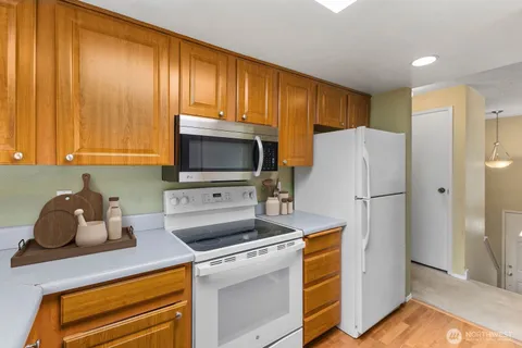 a kitchen with a refrigerator sink and cabinets