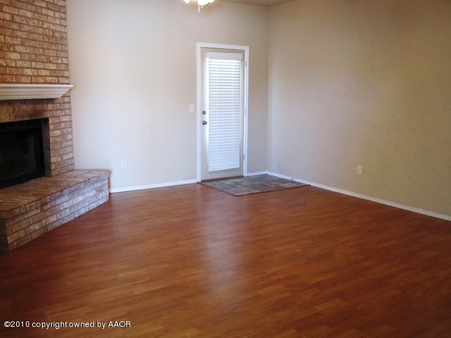 1140 Shasta Drive Amarillo, TX 79110 - Photo 4 of 23 a view of an empty room with wooden floor and a fireplace