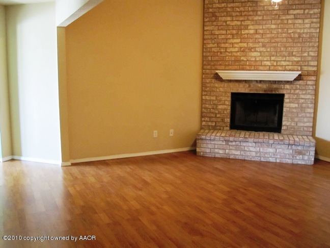 1140 Shasta Drive Amarillo, TX 79110 - Photo 5 of 23 a view of an empty room with wooden floor and a fireplace