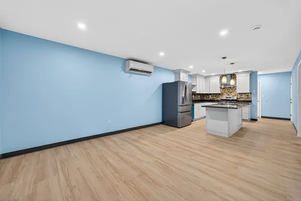 a kitchen with stainless steel appliances a refrigerator and a wooden floor