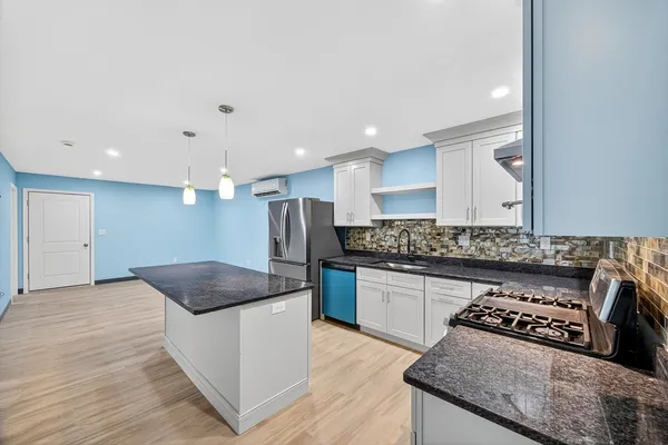 a kitchen with stainless steel appliances granite countertop a sink and a stove