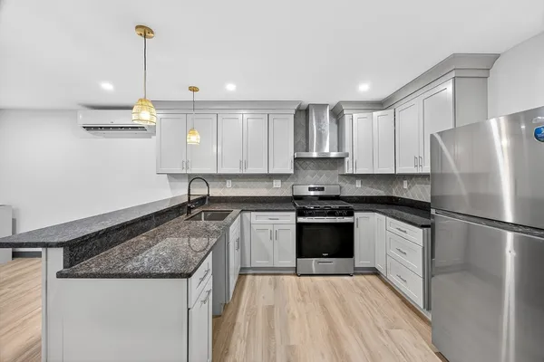 a kitchen with a refrigerator a sink and white cabinets
