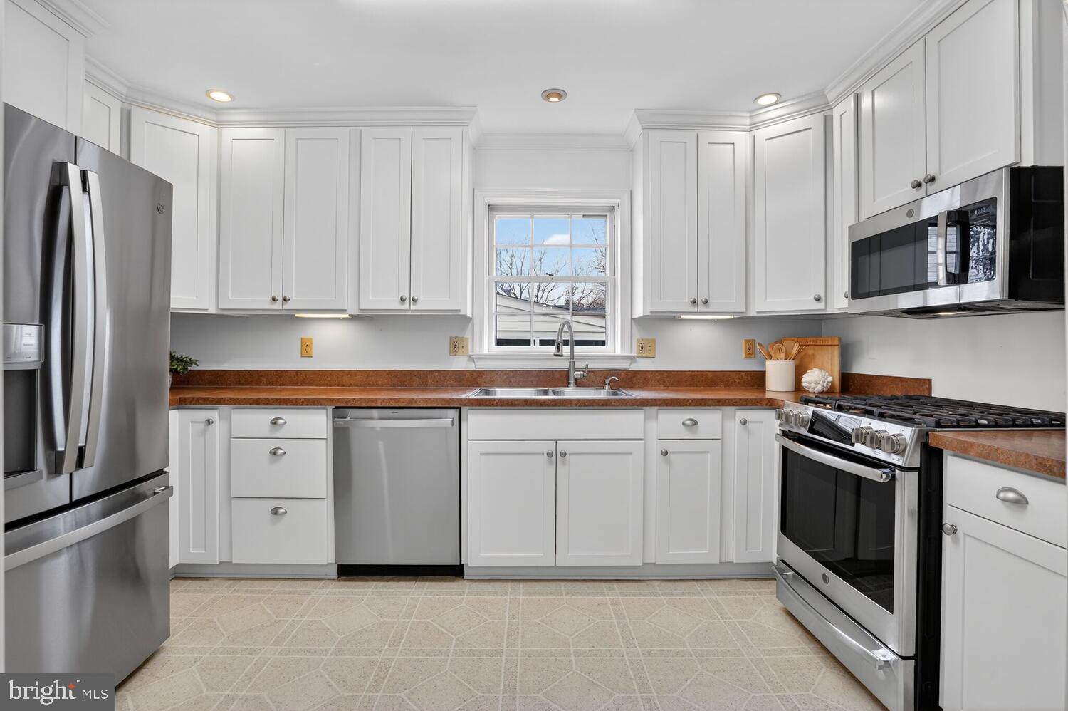 2420 Cameron Mills Road Alexandria, VA 22302 - Photo 16 of 45 a kitchen with granite countertop white cabinets and stainless steel appliances
