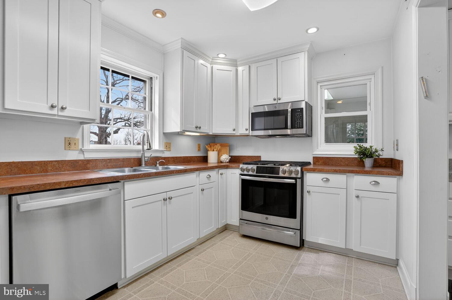 2420 Cameron Mills Road Alexandria, VA 22302 - Photo 17 of 45 a kitchen with granite countertop white cabinets and stainless steel appliances