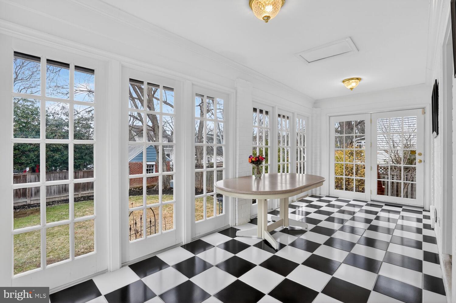 2420 Cameron Mills Road Alexandria, VA 22302 - Photo 21 of 45 a living room with a black white checkered floor with a gaming machine and dining chairs
