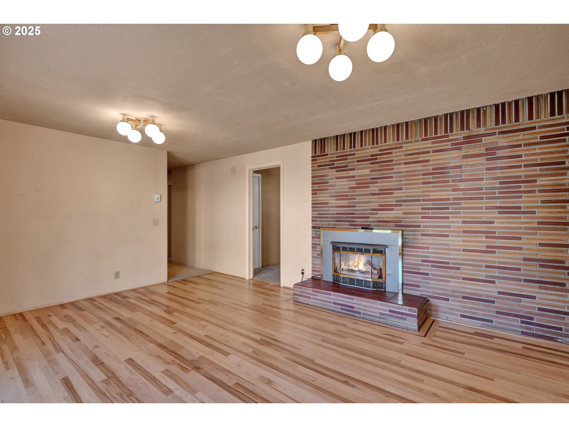 925 Ascot Drive Eugene, OR 97401 - Photo 16 of 44 a view of an empty room with wooden floor and a fireplace