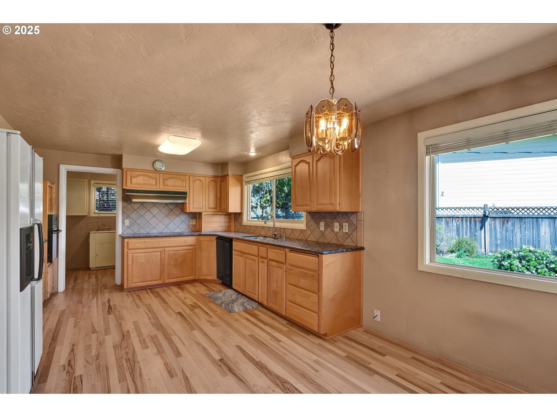 925 Ascot Drive Eugene, OR 97401 - Photo 10 of 44 a kitchen with stainless steel appliances granite countertop a refrigerator a sink dishwasher a stove and white countertops with wooden floor