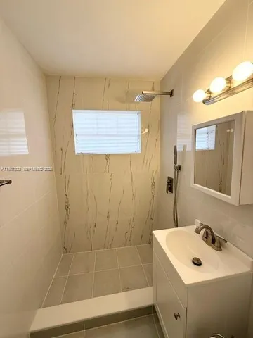a bathroom with a sink a shower and a mirror